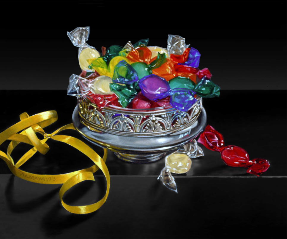 Des bonbons de toutes les couleurs dans une coupe ancienne en argent et un bolduc sur une table noire